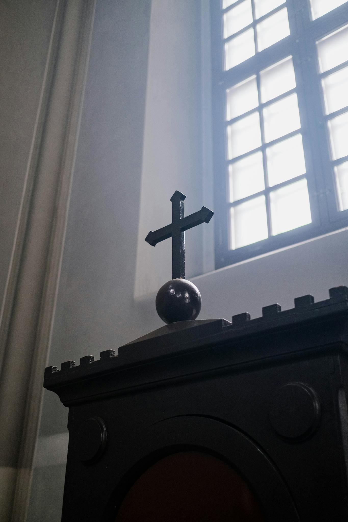 Low angle view of a cross in a church setting, symbolizing faith and spirituality.